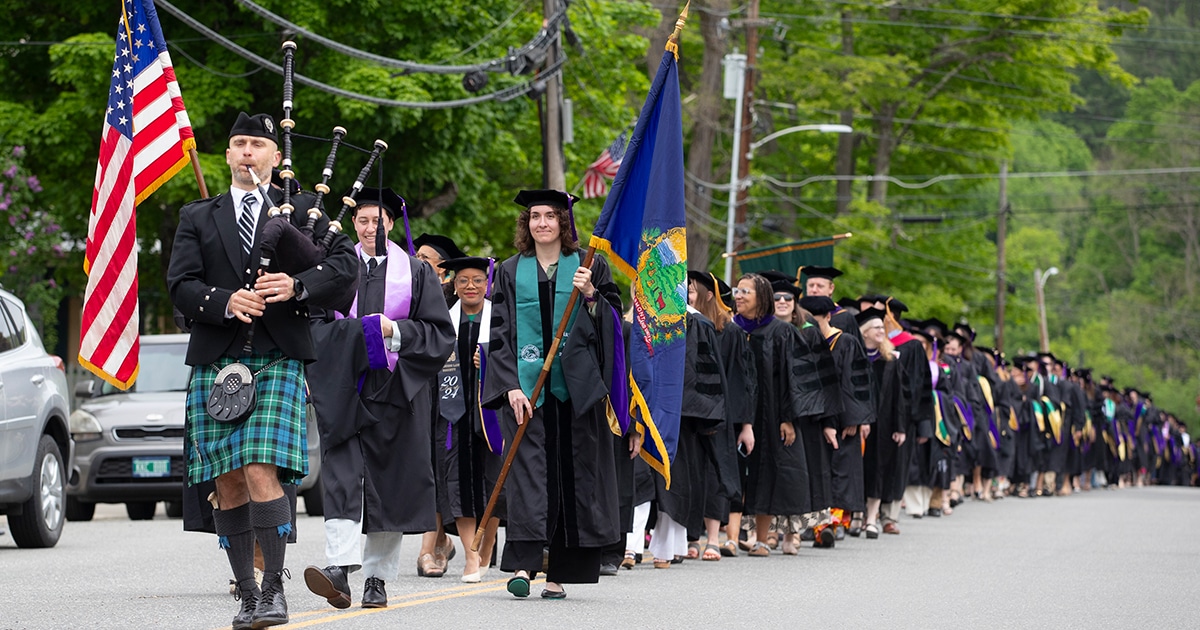 Led by bagpiper, the 2024 graduates march to the Royalton Town Green for Commencement.